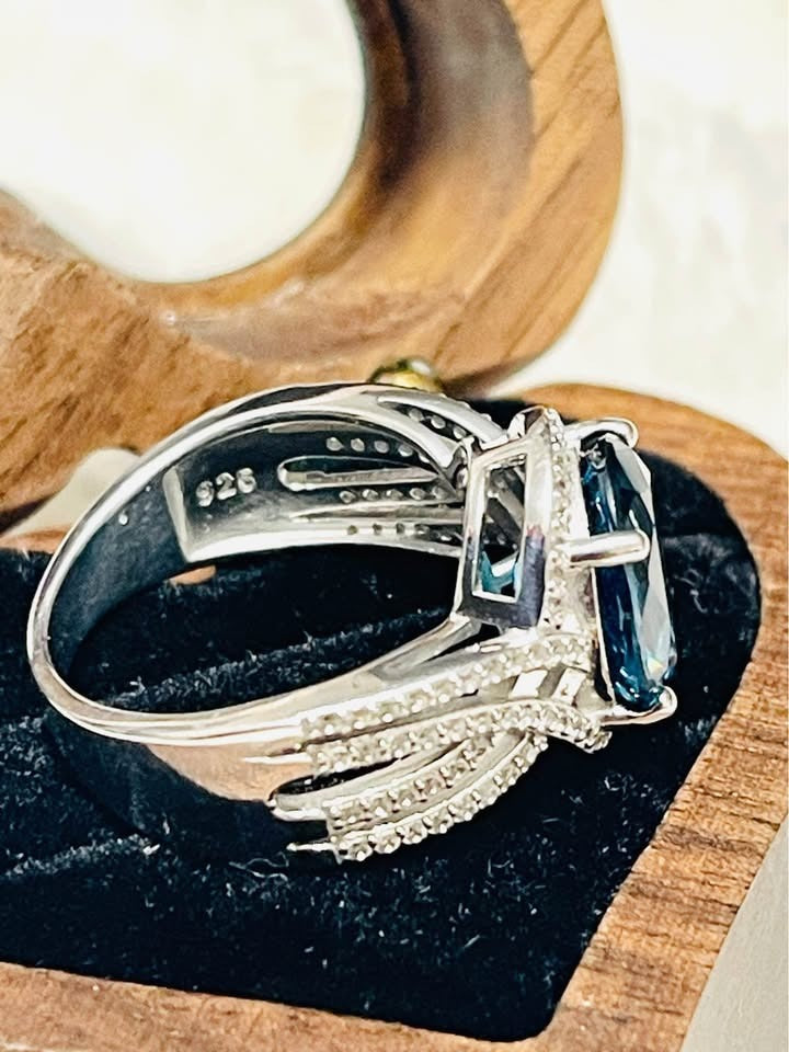 Close-up side view of a London Blue Topaz and diamond ring, showing the 925 sterling silver hallmark.
