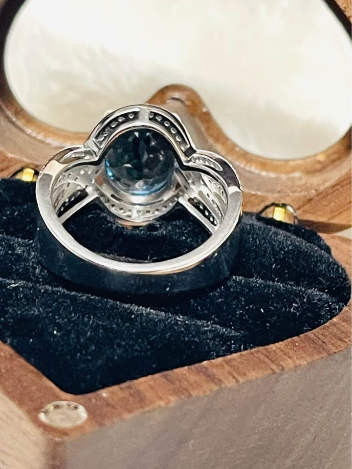 Back view of a London Blue Topaz and diamond ring, showcasing intricate silver setting and gemstone's deep blue.