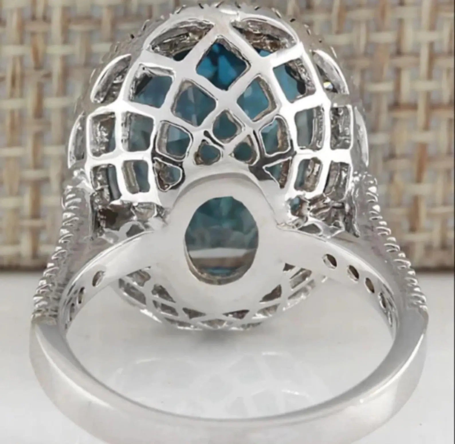Underside view of a London Blue Topaz halo ring, showcasing intricate filigree work and setting.