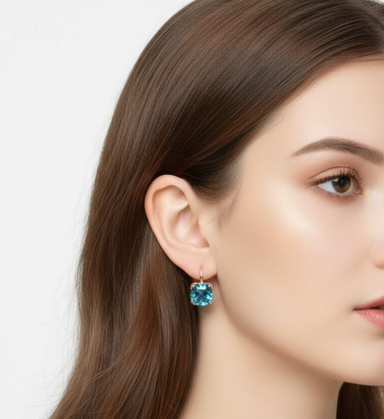 14K rose gold London Blue Topaz earring worn on an ear, showcasing its stunning blue hue.