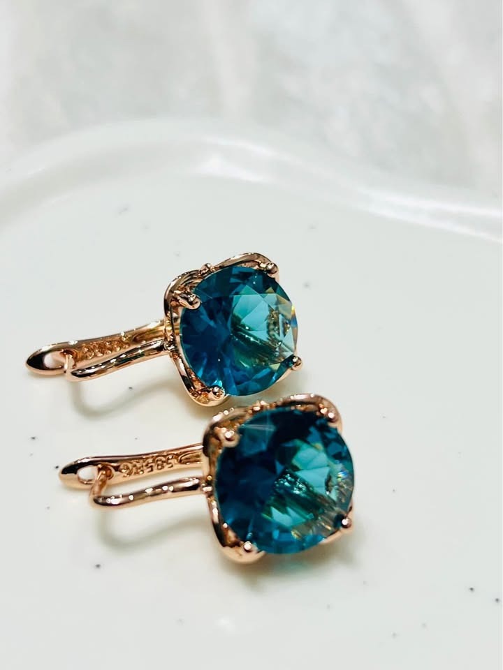  Close-up of 14K rose gold London Blue Topaz earrings, showcasing gemstone brilliance.