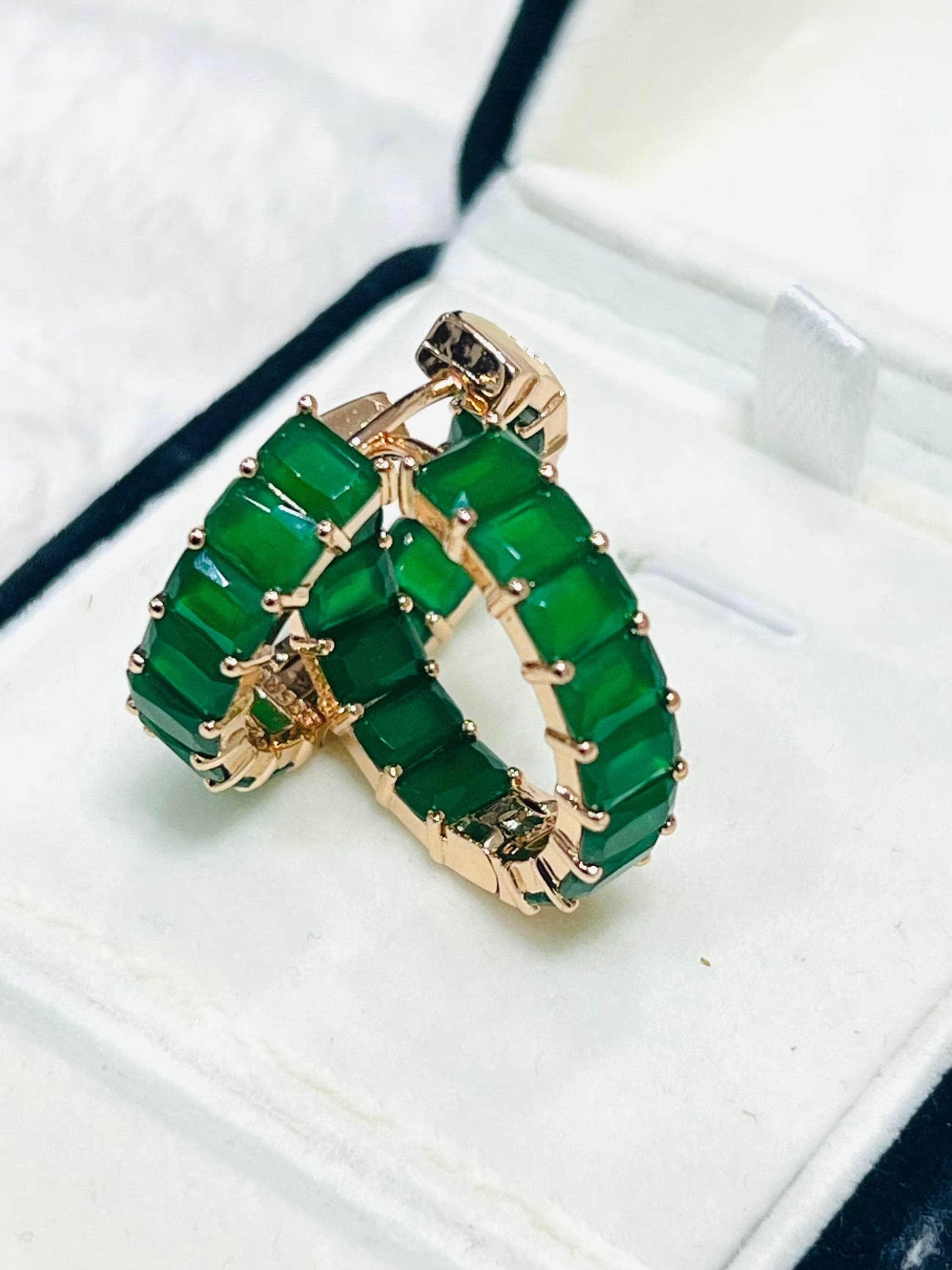 Elegant matrix emerald hoop earrings in a rose gold setting, displayed in a white jewelry box.