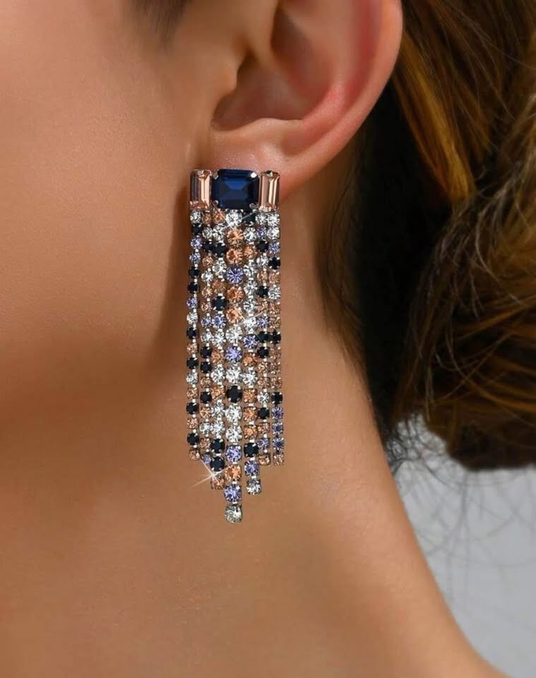 A model wearing elegant waterfall dangle earrings. The design features a mix of colorful gemstones for a striking look.