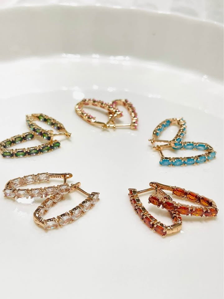 An arrangement of multi-colored inside-out tourmaline hoops in various shades, including pink, blue, and green.