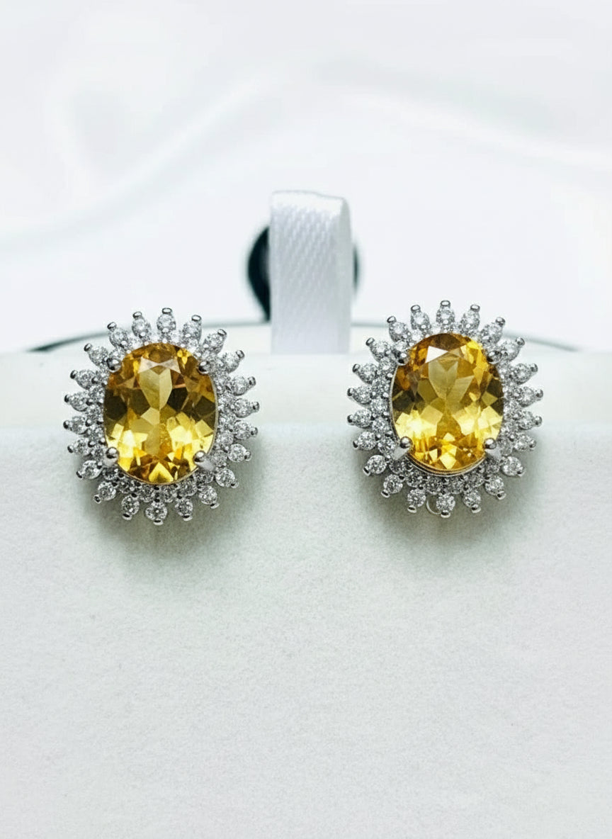Front view of natural citrine oval halo earrings displayed in an elegant jewelry box.