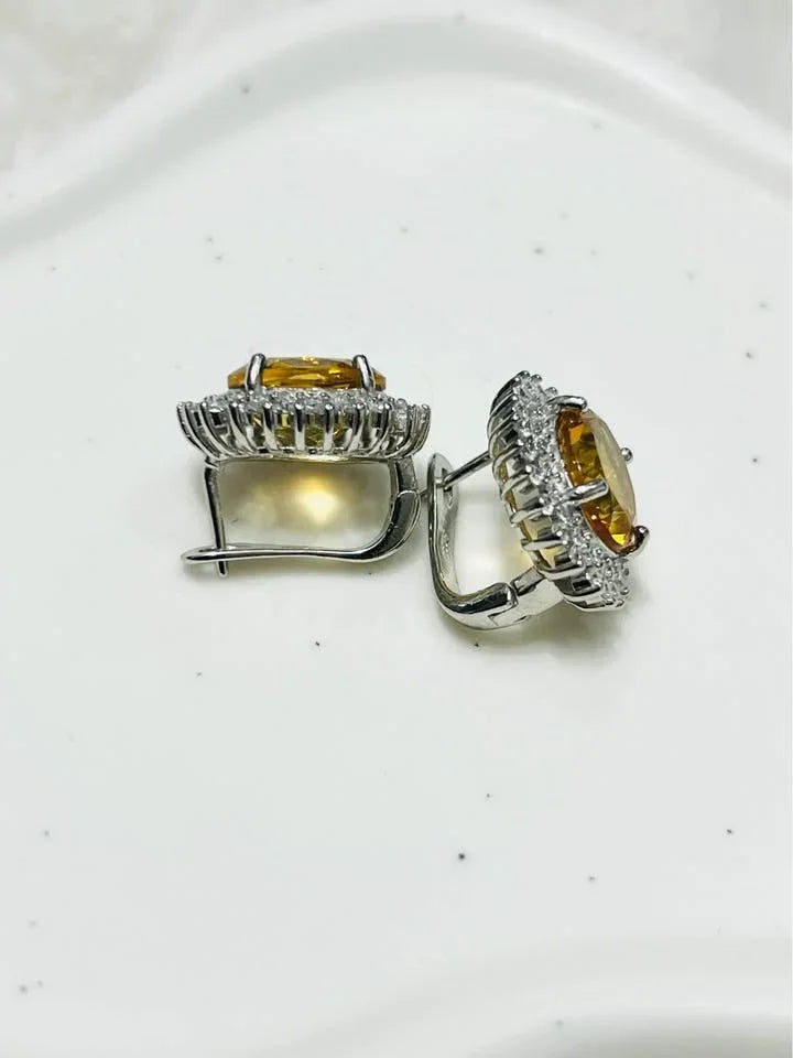  Side view of natural citrine oval halo earrings, showcasing design and clarity on white.