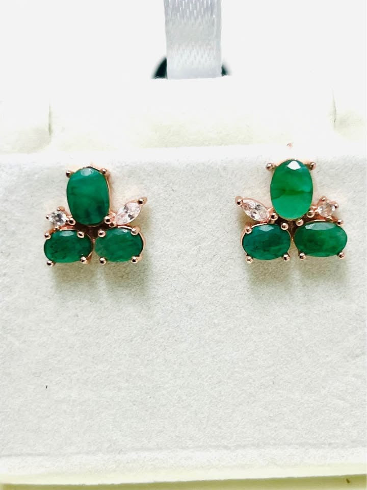 Natural Colombian emerald earrings with dazzling sparkle, displayed in a white jewelry box.