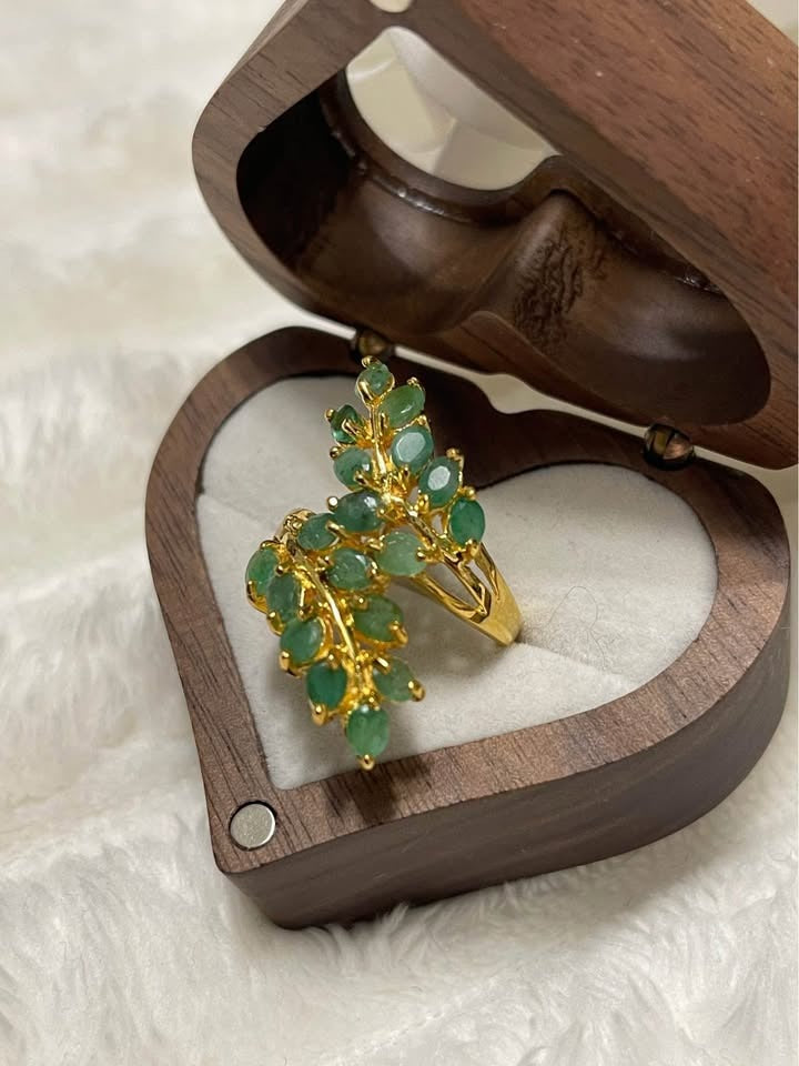  A detailed view of a sterling silver ring featuring natural, unheated Colombian emeralds in a leaf design.
