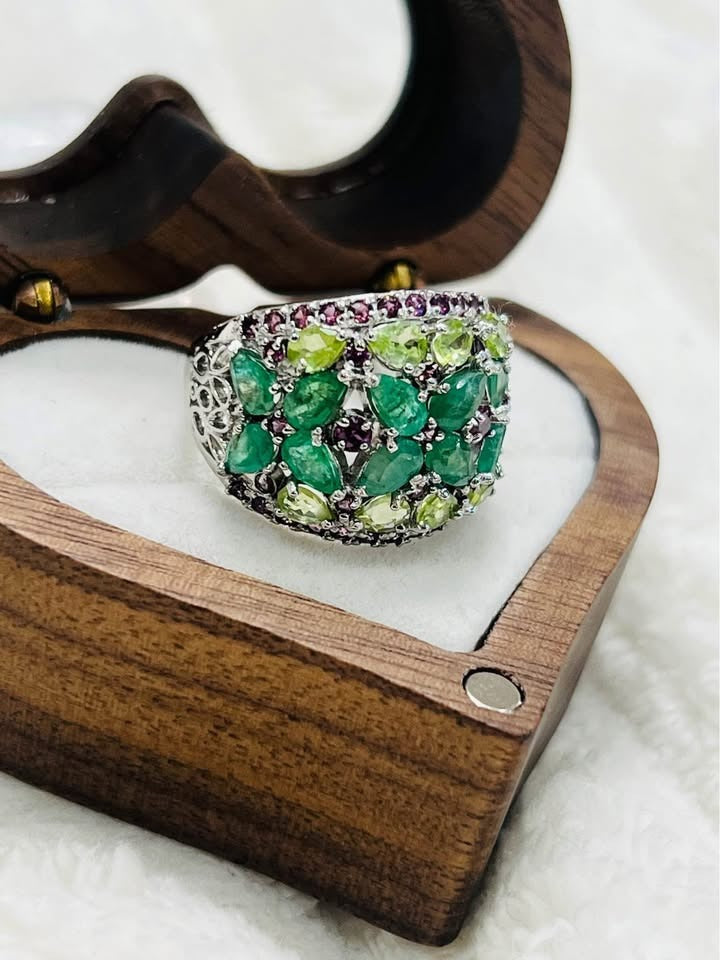Close-up of a 4.6 carat cocktail ring, highlighting the multi-gemstone cluster of emerald, peridot, and garnet.