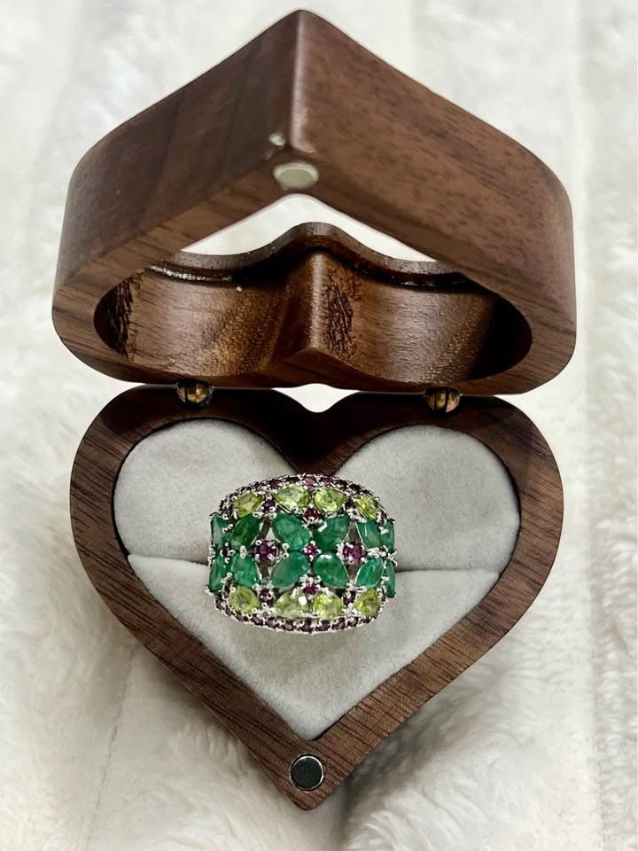 A stunning 4.6 carat ring featuring a cluster of natural emeralds, peridots, and rhodolite garnets.