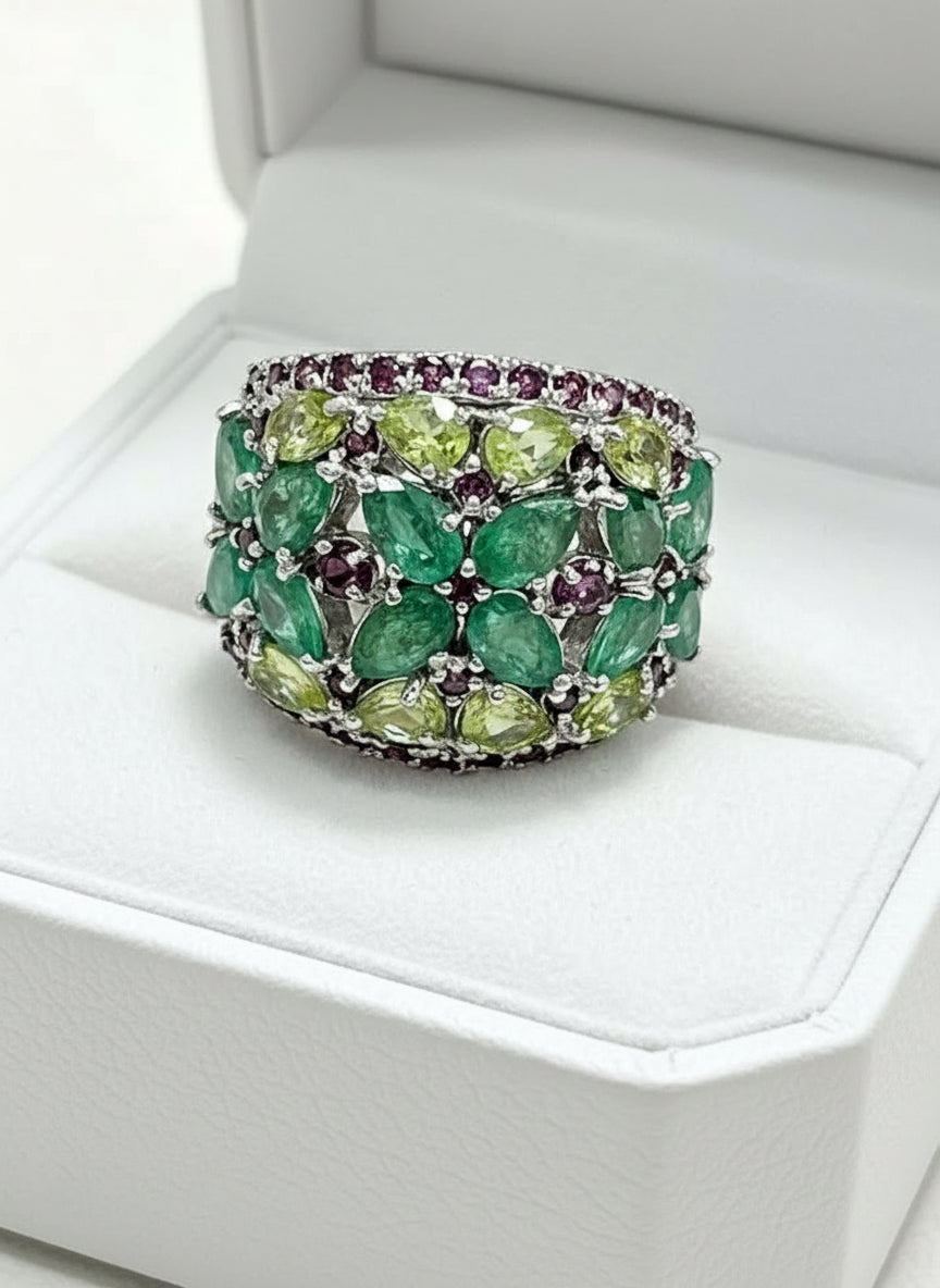 4.6 carat natural emerald, peridot, and rhodolite garnet cocktail ring on a woman's finger, showcasing its brilliance.