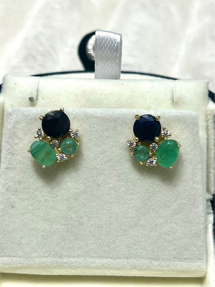 A pair of natural Colombian emerald and sapphire stud earrings with diamond accents.