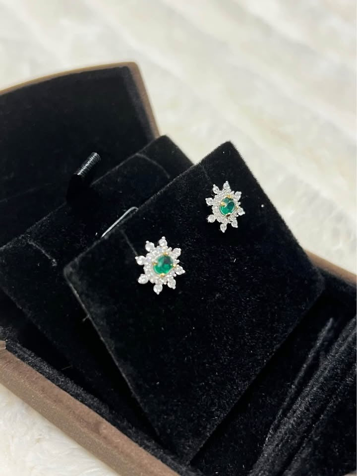 Natural emerald and white topaz flower stud earrings, beautifully displayed in a brown jewelry box.