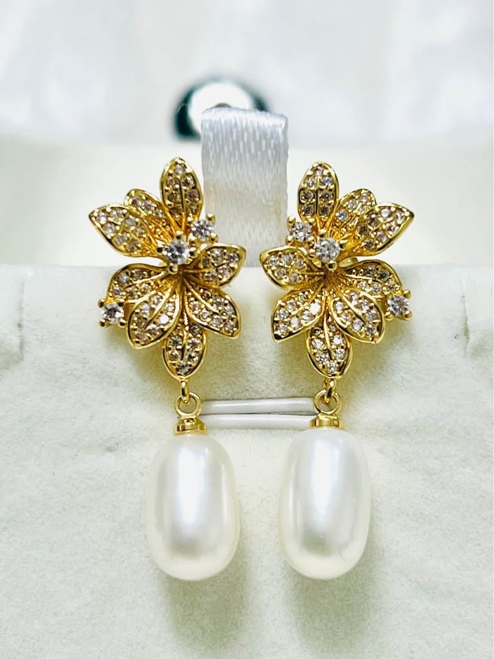 Elegant sterling silver gold vermeil earrings featuring natural pearl drops and dazzling floral designs.