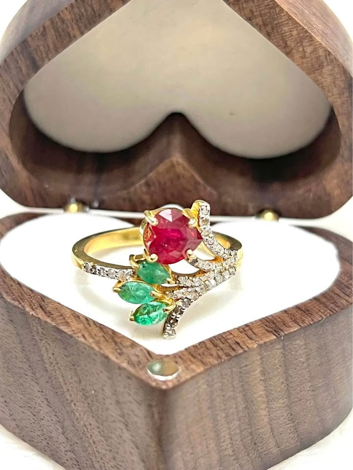 Elegant natural ruby, emerald, and diamond ring with a botanical design, presented in a wooden box.
