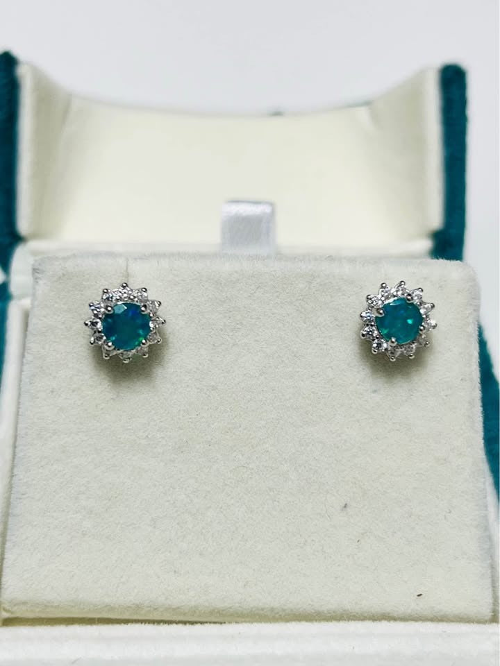  A pair of beautiful natural silver stud earrings featuring a central blue fire opal and surrounding cubic zirconia.