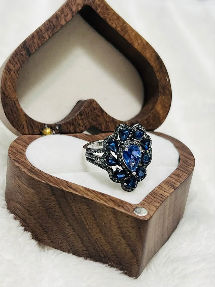Wide shot of a beautiful blue tanzanite and sapphire cocktail ring, showcasing the intricate floral design.
