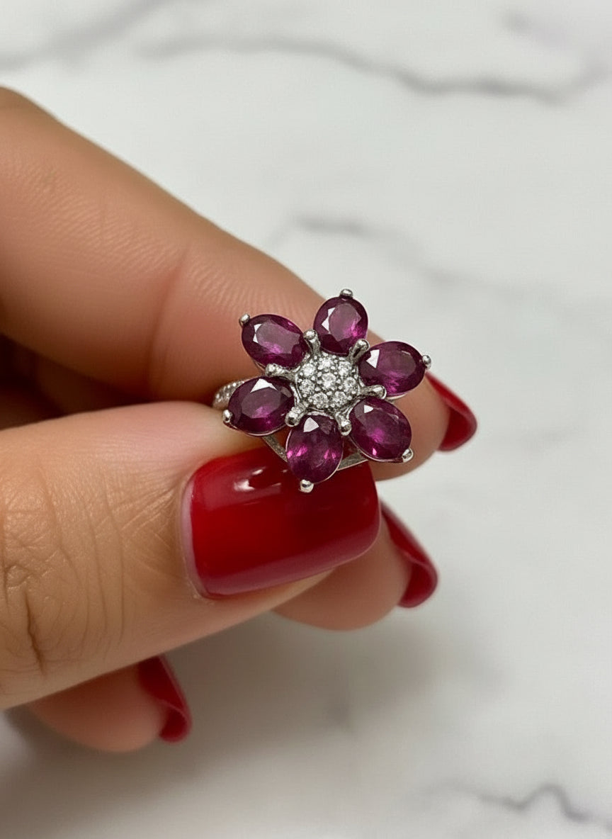 Front view of a natural ruby flower-shaped ring with dazzling white accent stones.