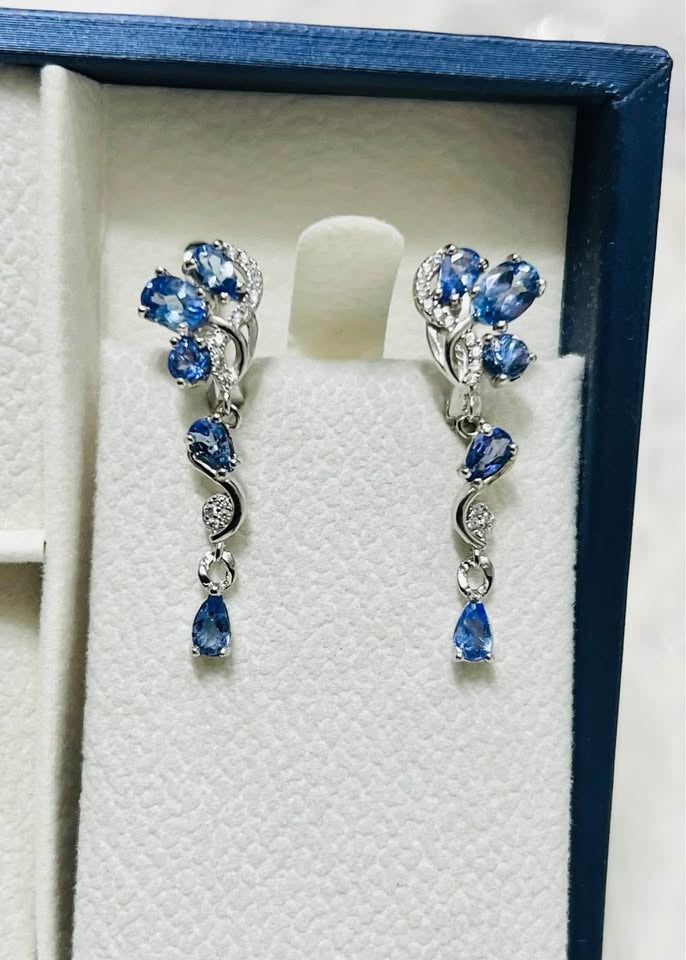 Natural tanzanite dangle earrings in a sterling silver setting with delicate pave accents.
