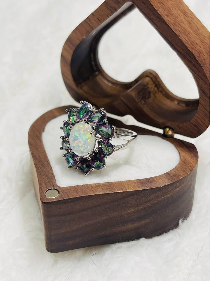  Side view of the opal and mystic topaz ring, highlighting the setting and the heart-shaped wooden box.