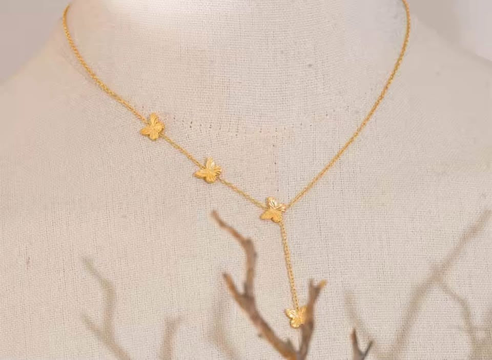 Elegant 18k gold vermeil Papillon D'Or necklace with butterfly charms, displayed on a mannequin.