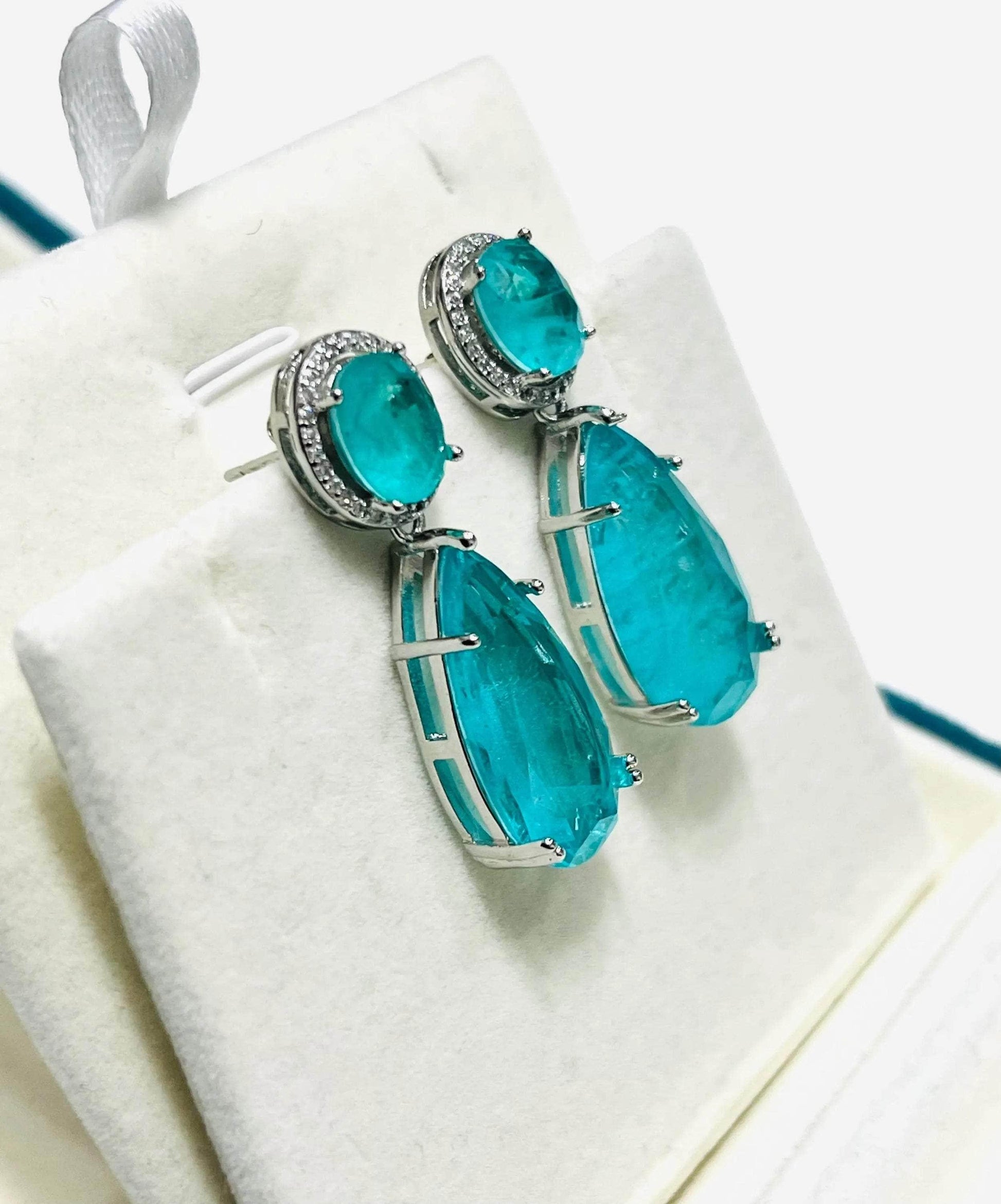  Vibrant Paraiba tourmaline dangle earrings, set in white gold, presented in a jewelry box.