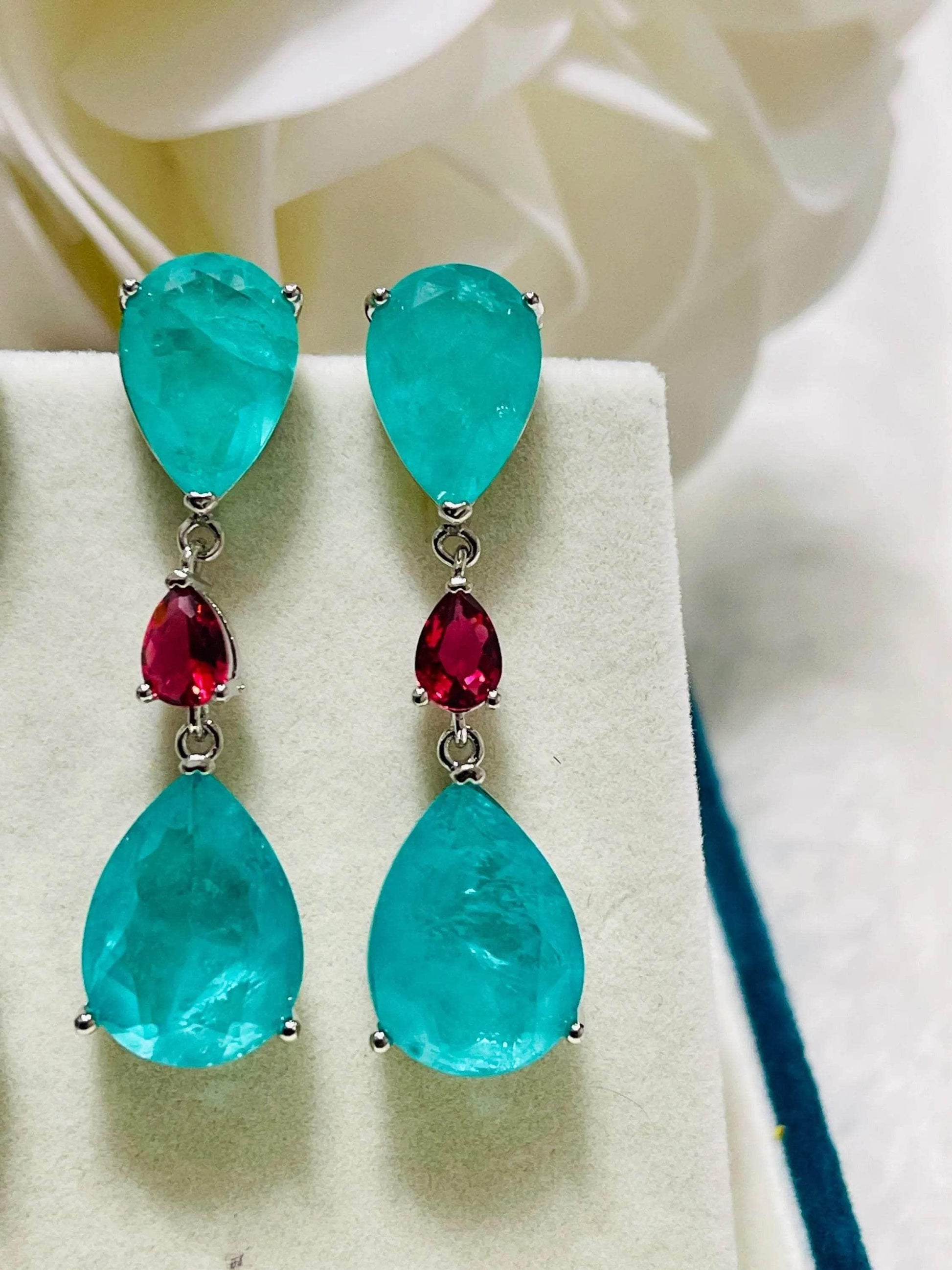 Pair of stunning blue-green Paraiba doublet drop earrings featuring red accent stones.