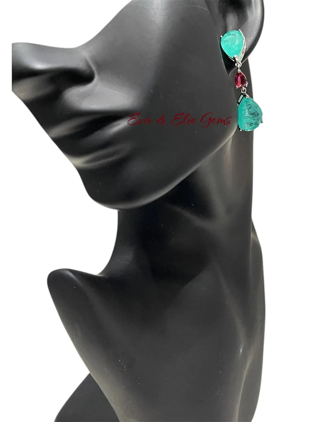 Blue-green Paraiba doublet drop earring with a red accent stone on a black mannequin ear.