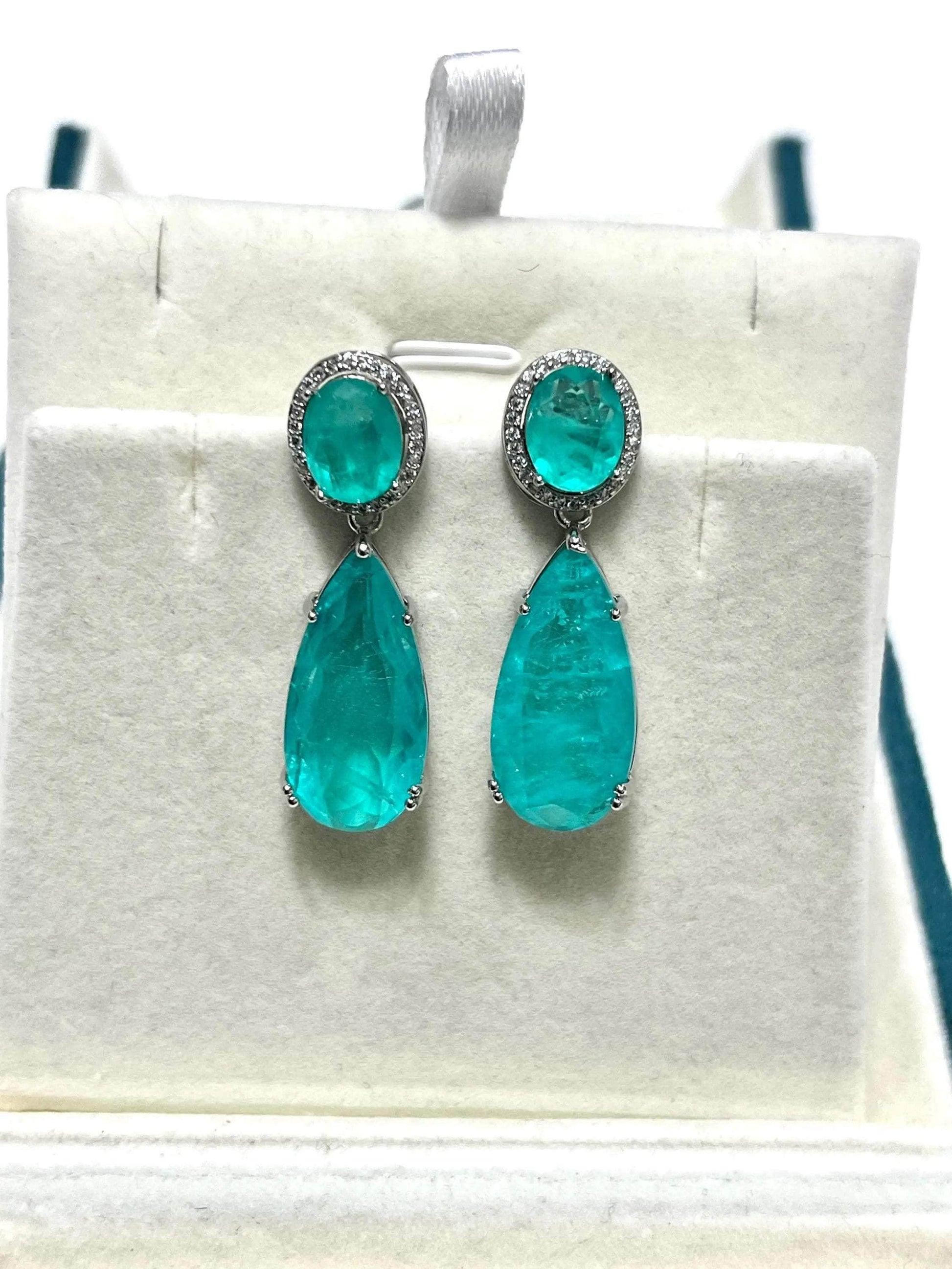  Bright Paraiba tourmaline earrings featuring a round top stone with a sparkling halo and a large drop.