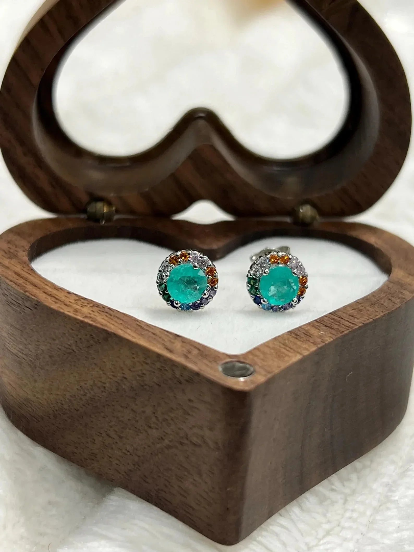 Dazzling Paraiba Tourmaline earrings with a colorful halo, displayed in a charming heart-shaped box.