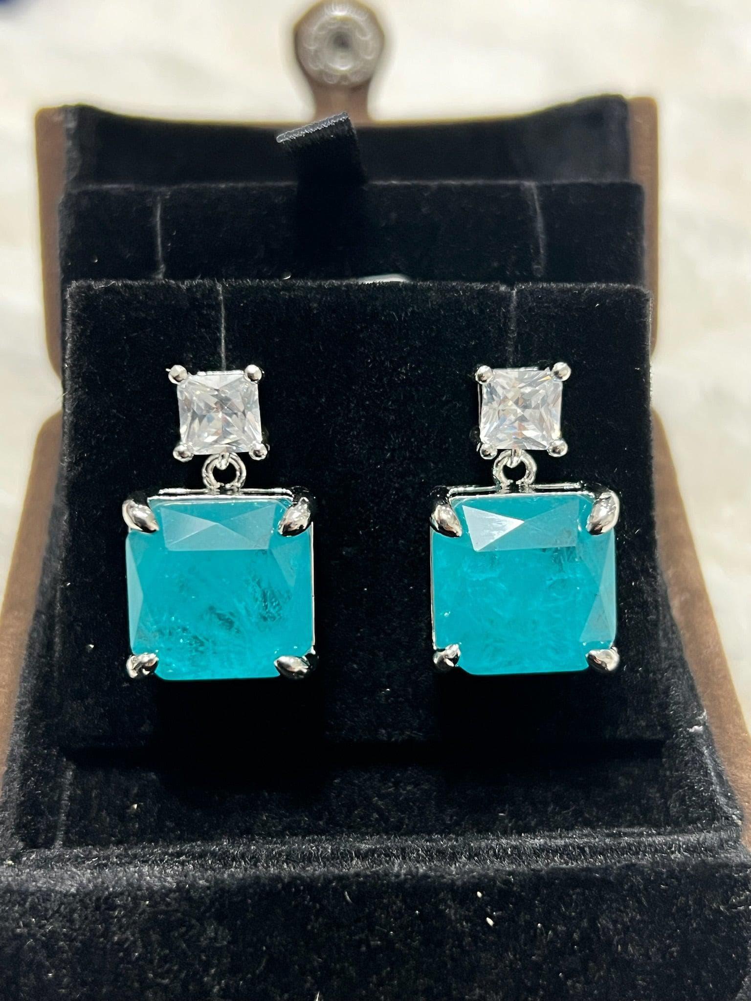 Exquisite emerald-cut Paraiba tourmaline earrings with sparkling accent stones, front view in gift box.