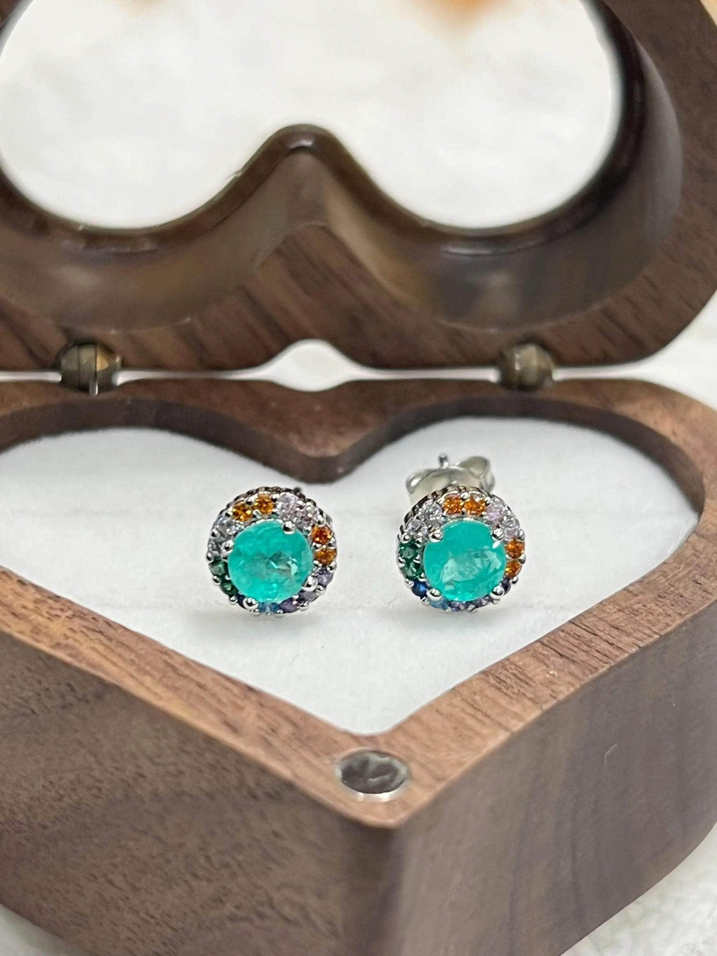 Exquisite Paraiba Tourmaline studs in 14K gold & sterling silver, nestled in a heart-shaped wooden box.