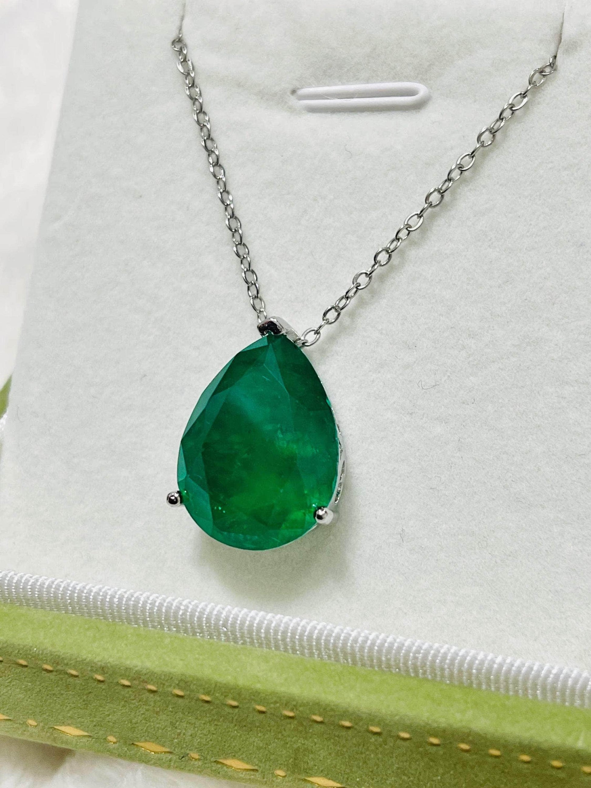 Beautiful pear-cut Zambian emerald doublet pendant with a silver chain, resting in a gift box.