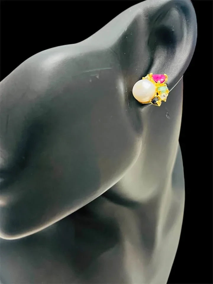 Single South Sea pearl earring with emerald, ruby, and topaz, displayed on a black mannequin ear.