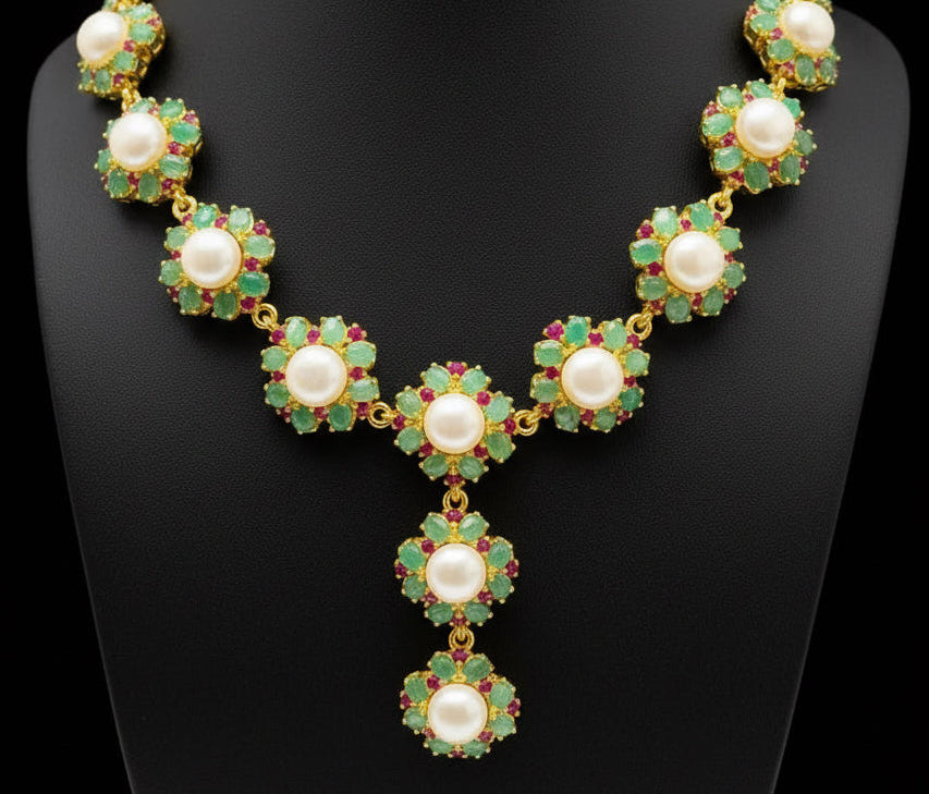 Detailed close-up of a luxurious South Sea pearl, Colombian emerald, and ruby necklace.