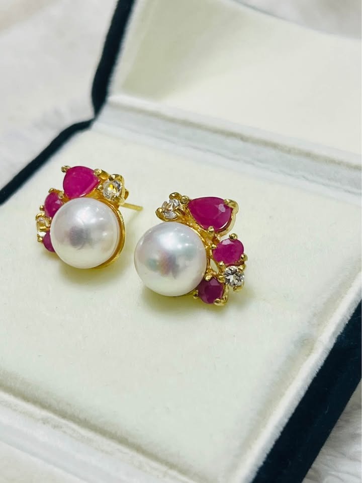Artisan-made South Sea pearl, ruby, and white topaz earrings in a jewelry box, showing their elegant design.