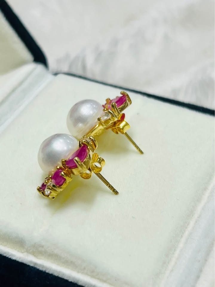 Side profile of artisan South Sea pearl earrings, highlighting ruby, white topaz, and post closures.
