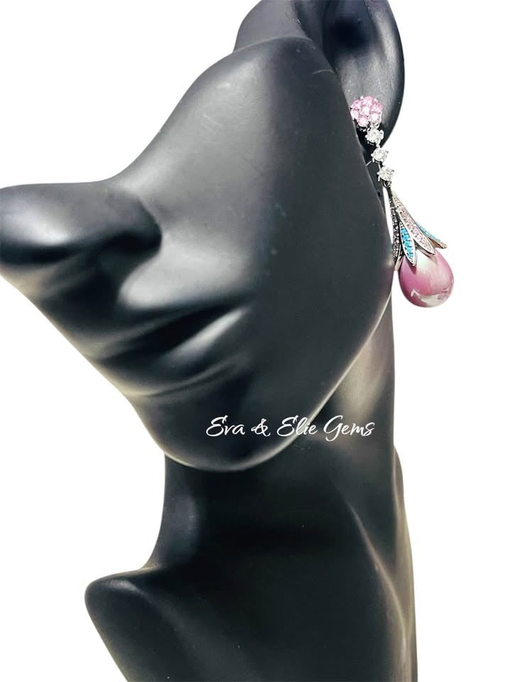 Stylish pink pearl and turquoise earrings displayed on a mannequin head, showcasing their elegant length.