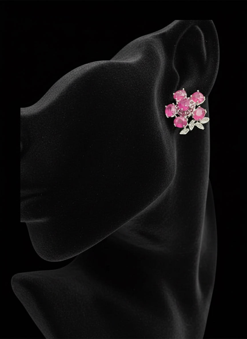A mannequin wearing sterling silver stud earrings with a stunning cluster of natural pink ruby gemstones.