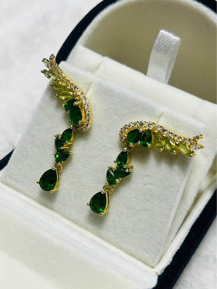 Real chrome diopside and peridot angel earrings, vibrant green hues, displayed in a jewelry box.