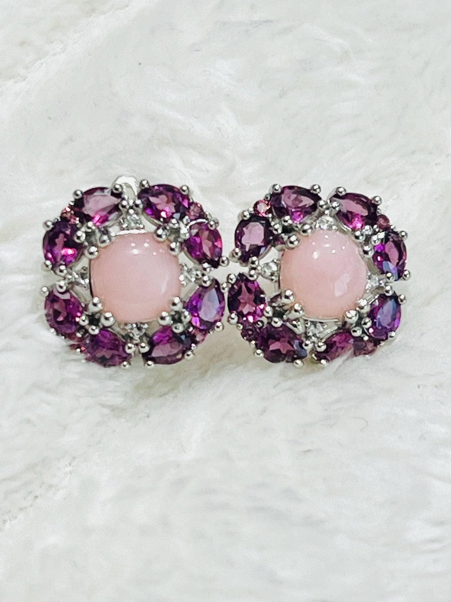 A pair of sterling silver floral earrings, each featuring a pink rose quartz surrounded by deep pink rhodolite garnets.