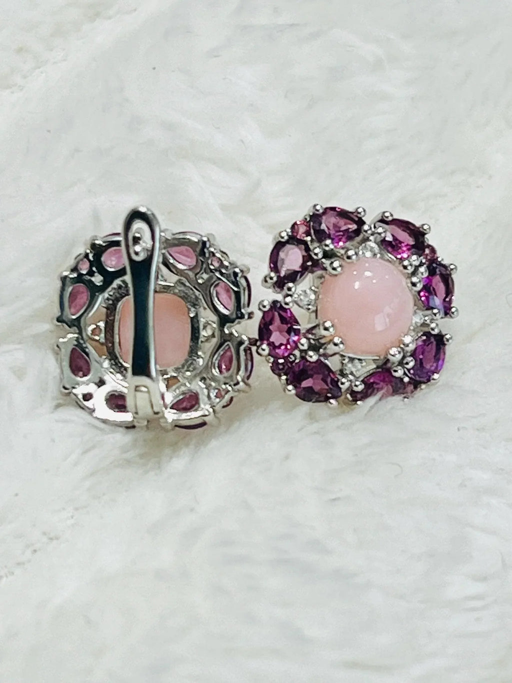 Close-up of two sterling silver earrings with rhodolite and rose quartz, showing the lever-back closure and gemstone settings.