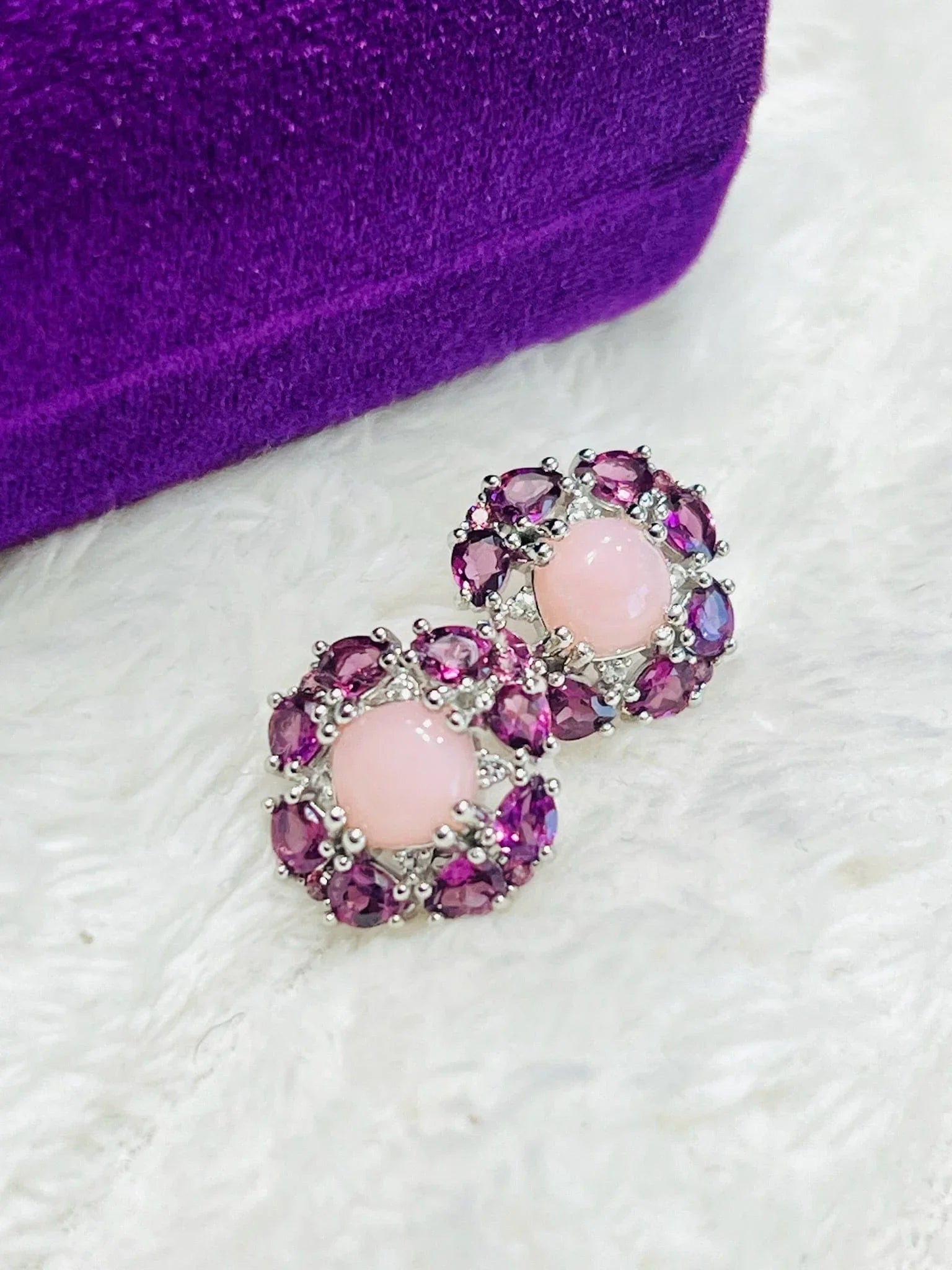 Pair of sterling silver earrings with pink rose quartz & purple rhodolite garnets, on purple velvet