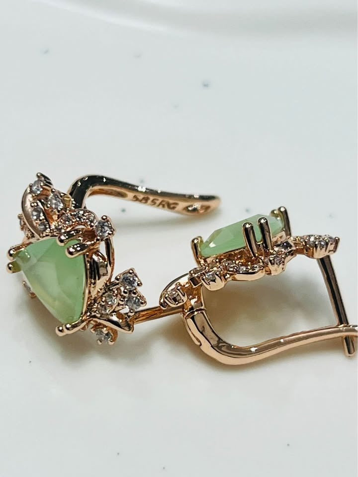 Side view of 14k rolled gold earrings with a vibrant green prehnite gemstone and intricate filigree detail.