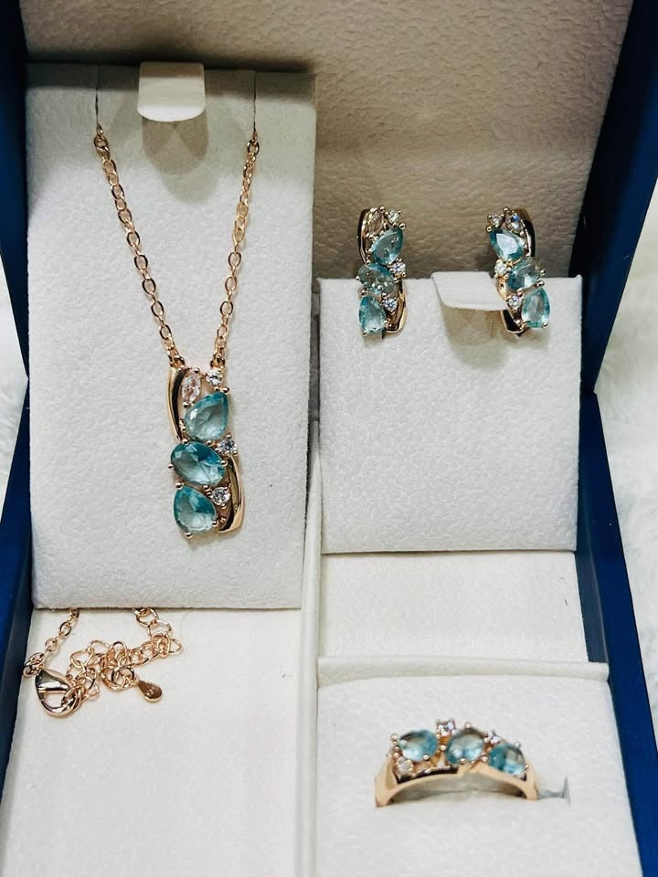 Complete rose gold jewelry collection with light blue aquamarine stones, including a necklace, earrings, and ring.