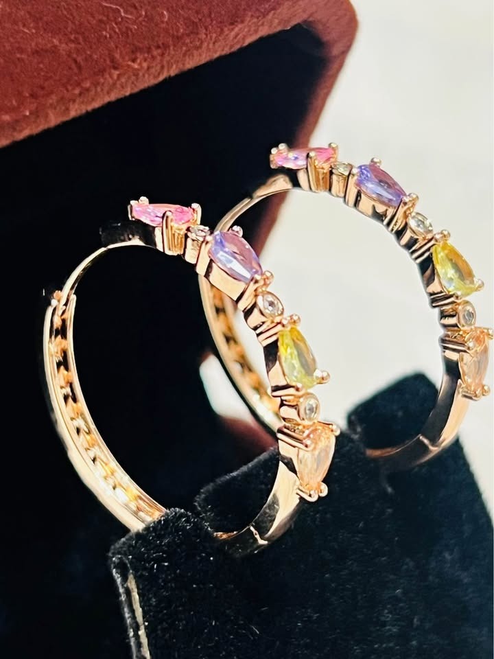 Close-up of 585RG rose gold stacked tourmaline hoop earrings with vibrant multi-colored gemstones in a box.