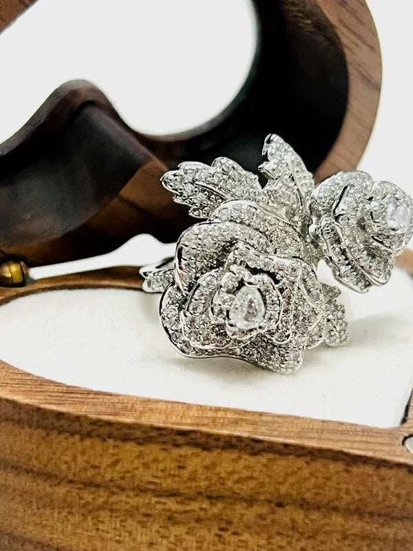 Detailed shot of a rose-shaped gold vermeil CZ statement ring, showcasing its sparkle in a wooden jewelry box.