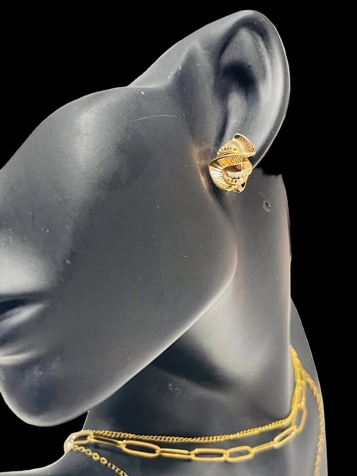 Model wearing 585RG stamped rose gold twist earrings with sparkling stones, showcasing fit and style.