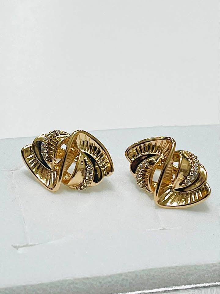 Close-up of 585RG stamped rose gold twisted earrings with pave-set cubic zirconia, elegant jewelry.