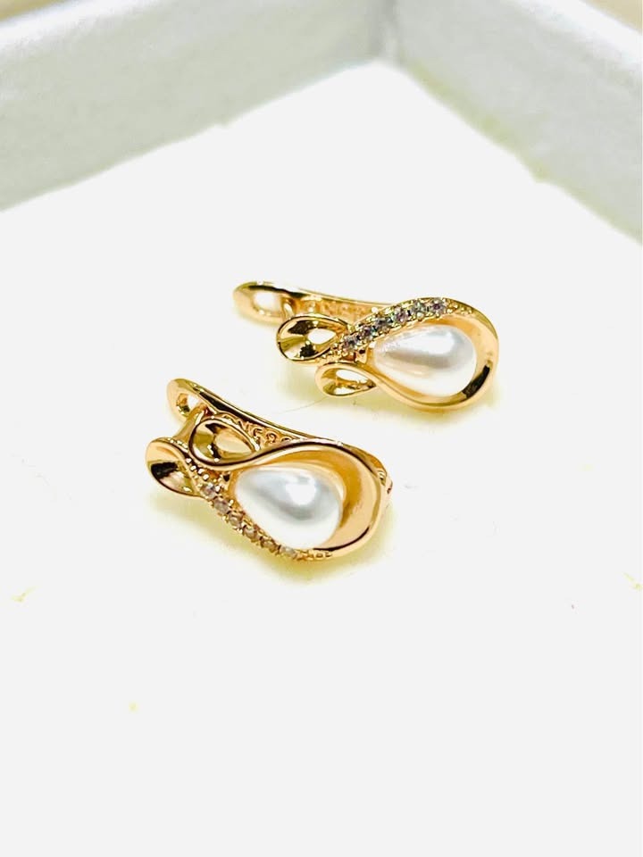 Close-up of 585RG stamped 14K equivalent rose gold earrings featuring elegant teardrop pearls.